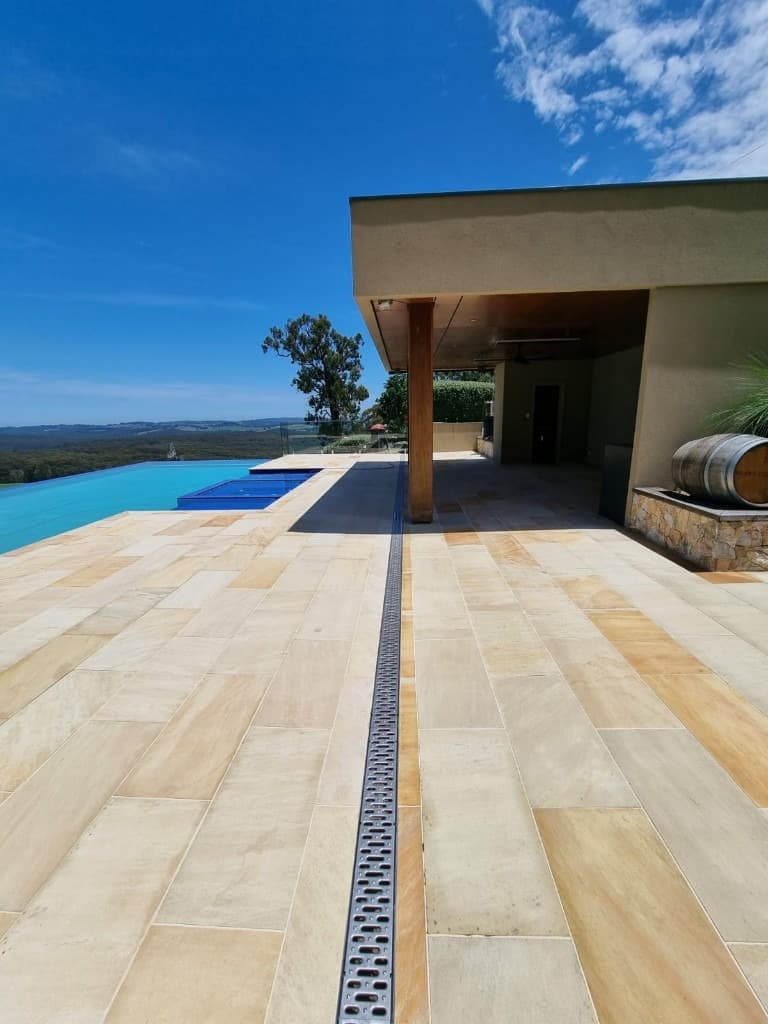 Luxury sandstone patio and infinity pool overlooking rolling hills