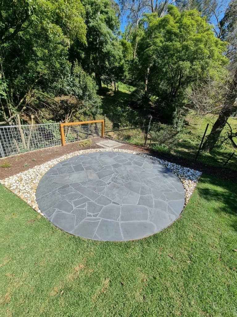 Crazy paving flagstone patio with river pebble border