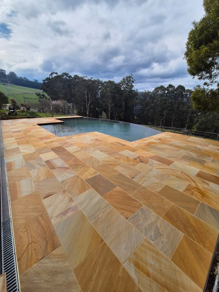 Sandstone pool paving with infinity edge overlook