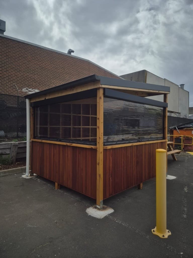 Custom timber outdoor shelter with roll-down screens